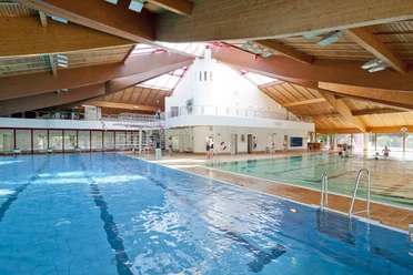 Hildorado Schwimmbad in Hilden Ein großes Schwimmbad mit verschiedenen Bereichen, natürlichem Licht und einer Holzarchitektur.