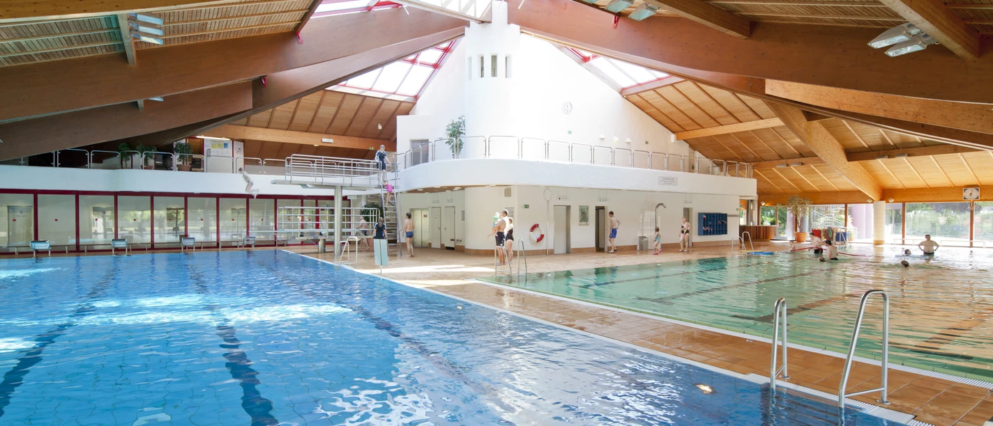 Hildorado Schwimmbad in Hilden Ein großes Schwimmbad mit verschiedenen Bereichen, natürlichem Licht und einer Holzarchitektur.