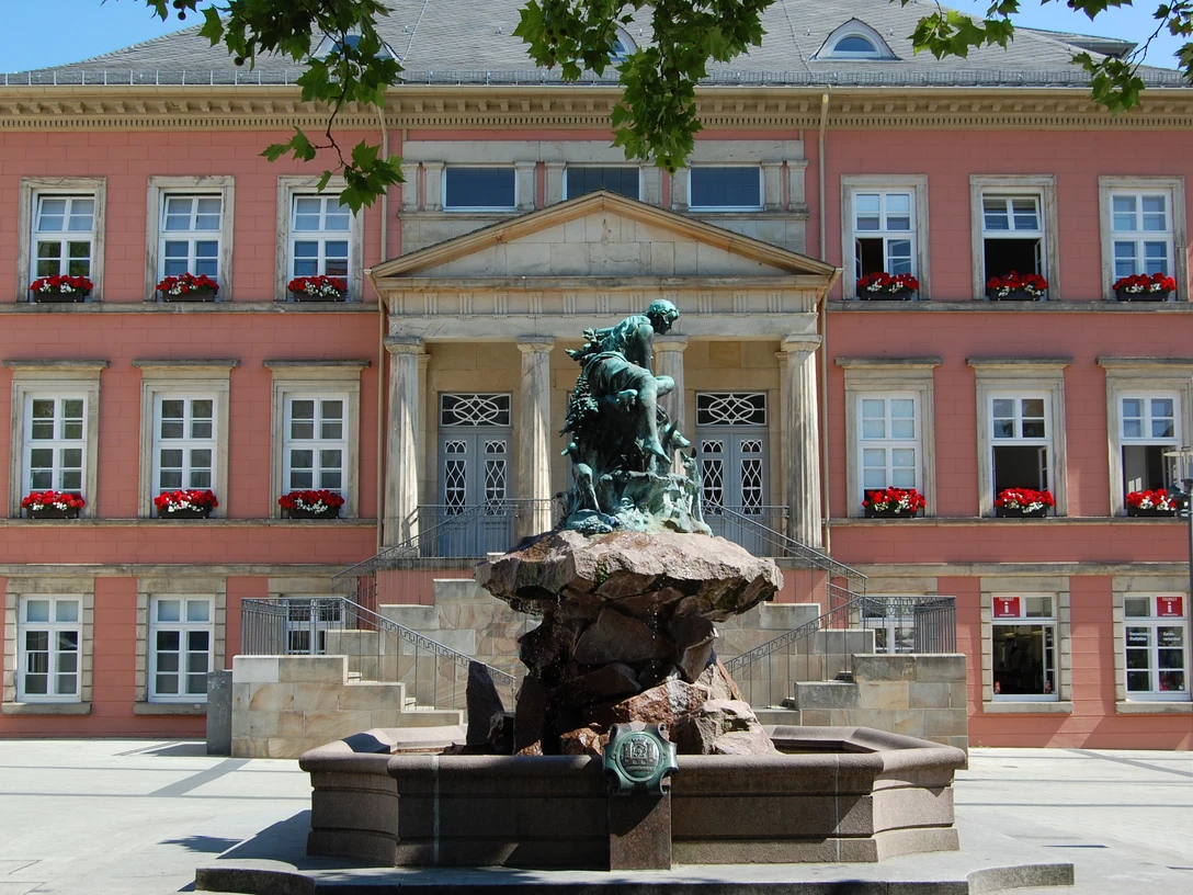 Donopbrunnen auf dem Detmolder Marktplatz Bronzefigur des Donopbrunnens vor dem historischen Gebäude des Detmolder Marktplatzes.