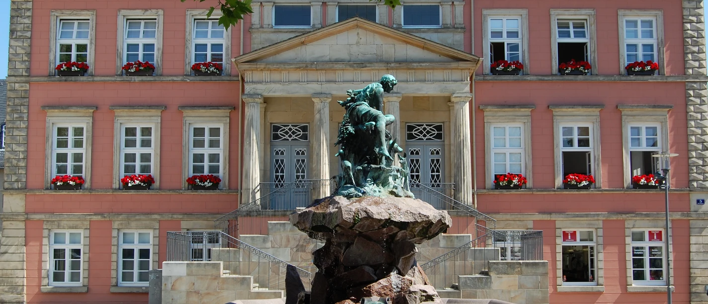 Donopbrunnen auf dem Detmolder Marktplatz Bronzefigur des Donopbrunnens vor dem historischen Gebäude des Detmolder Marktplatzes.