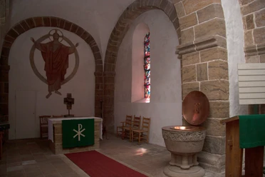 Kirche Bucholz Innen Altar Im Inneren der Kirche Buchholz sind der Altar mit hohem Kreuz und ein farbenreiches Fenster zu sehen.