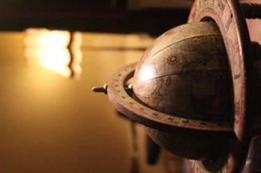 Ein antikes Modell eines Armillarsphärenglobus mit detaillierten Symbolen und leichtem Lichteinfall.