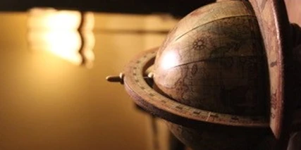 Ein antikes Modell eines Armillarsphärenglobus mit detaillierten Symbolen und leichtem Lichteinfall.