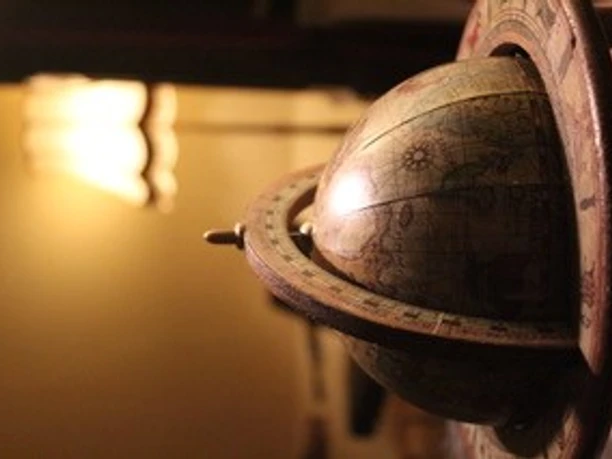 Ein antikes Modell eines Armillarsphärenglobus mit detaillierten Symbolen und leichtem Lichteinfall.