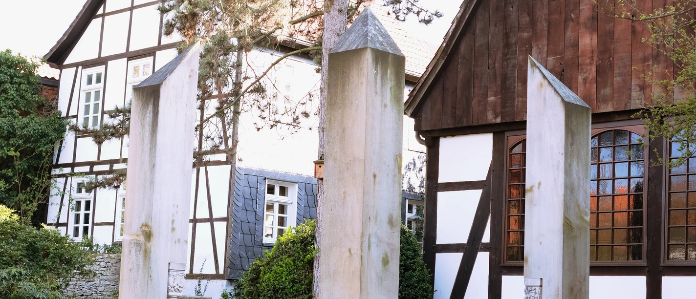 Gedenkstätte für die Opfer der nationalsozialistischen Gewaltherrschaft in Detmold, hinter der alten Synagoge Gedenkstätte mit vier minimalistisch gestalteten Stelen aus hellem Stein, umgeben von Fachwerkbauten.
