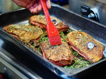 Gänsebraten der Hofküche der Gänsefarm Eskildsen - Regionale Produkte Lecker zubereitete, gegrillte Gänsebrust der Gänsefarm Eskildsen wird mit Öl bestrichen, regionale Produkte