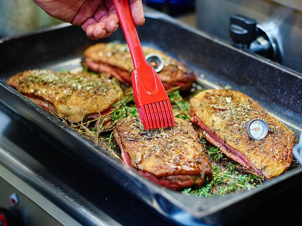 Gänsebraten der Hofküche der Gänsefarm Eskildsen - Regionale Produkte Lecker zubereitete, gegrillte Gänsebrust der Gänsefarm Eskildsen wird mit Öl bestrichen, regionale Produkte