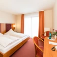 Hotelzimmer im Hotel-Restaurant Zum Vater Rhein in Monheim am Rhein Hotelzimmer mit zwei Einzelbetten, Schreibtisch, Flachbildfernseher, helle Vorhänge und rote Dekore.