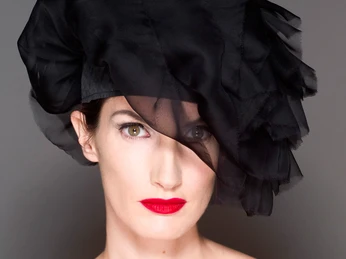 Schwarzer Damenhut von Gela-Hüte - Regionale Produkte Eine Frau trägt einen schwarzen Hut, der ihr seitlich ins Gesicht fällt, von Angela Wandelt aus der Hutmanufaktur Gela-Hüte in der Spinnerei Leipzig Plagwitz, regionale Produkte