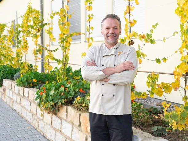 Chocolatier Olav Praetsch - Regionale Produkte Der Chocolatier Olav Praetsch steht mit verschränkten Armen und breitem Lächeln vor seiner Chocolaterie Praetsch Wermsdorf, regionale Produkte