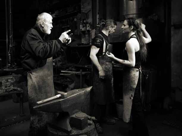 Familienbetrieb Schmiede Widdermann - Regionale Produkte Zwei Männer und eine Frau stehen in Arbeitskleidung im Familienbetrieb der Schmiede Widdermann in Hohenprießnitz, um Kunst- und Gebrauchsgegenstände in Schmiedeeisen herzustellen, regionale Produkte