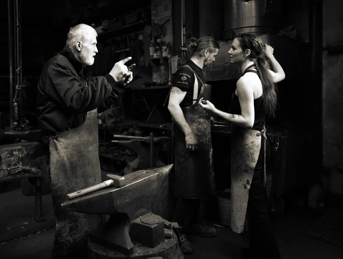 Familienbetrieb Schmiede Widdermann - Regionale Produkte Zwei Männer und eine Frau stehen in Arbeitskleidung im Familienbetrieb der Schmiede Widdermann in Hohenprießnitz, um Kunst- und Gebrauchsgegenstände in Schmiedeeisen herzustellen, regionale Produkte