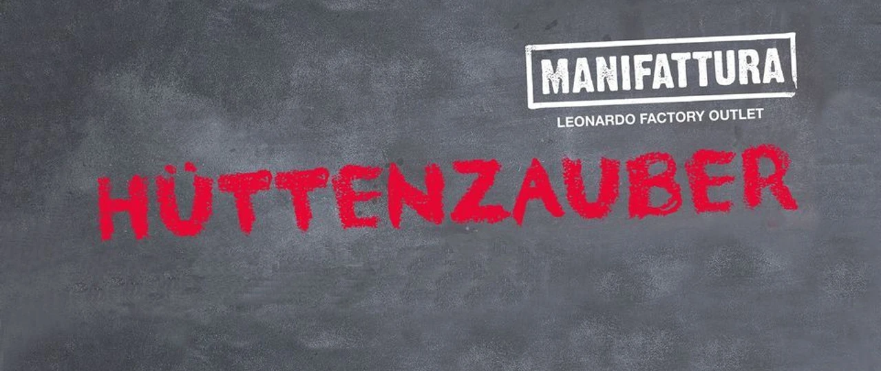 Hüttenzauber in der MANIFATTURA Große weiße Tafel mit dem Schriftzug "MANIFATTURA" und rotem darunterliegendem Wort "HÜTTENZAUBER".