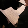 Ein Chorsänger liest Notenblätter während einer Probe bei einem Chorkonzert.