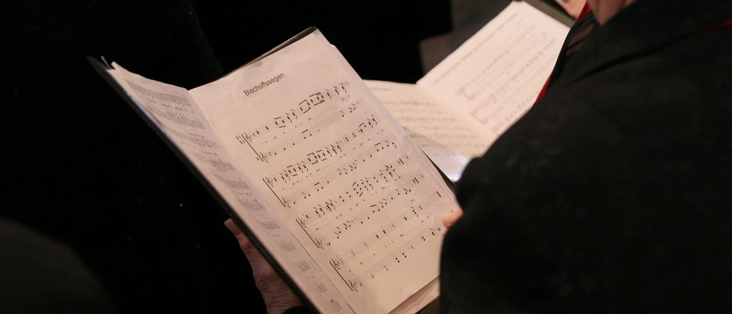 Ein Chorsänger liest Notenblätter während einer Probe bei einem Chorkonzert.