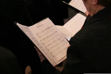 Chorkonzert Ein Chorsänger liest Notenblätter während einer Probe bei einem Chorkonzert.