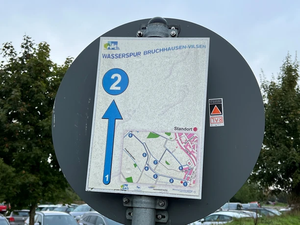 Wasserspur Bruchhausen-Vilsen Wegweiser an einem Rundwanderweg mit Karte und Pfeil. Ziel Bruchhausen-Vilsen, Punkt zwei markiert.
