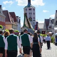 Guntiafest-Günzburg feiert mit seinen Gästen Menschen in traditioneller Tracht spazieren durch Günzburgs Altstadt; vorne der historische Uhrturm.