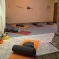 Yoga in der Natur-Klang-Raum Praxis im Spiegelhaus Woltzeten Yogaraum mit Matten, Bolstern und Klangschalen, sanft beleuchtet für Meditation und Entspannung.