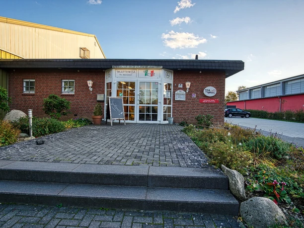 trattoria-resturant.jpg Eingangsbereich der Trattoria da Totti mit Treppe, Pflasterstein-Terrasse und Backsteinfassade.