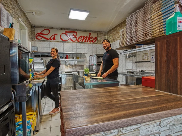 DSC07114_11la-benko.jpg Innenansicht der Pizzeria La Benko: Zwei Mitarbeiter bereiten frische Speisen in der offenen Küche zu.