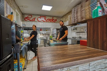 Innenansicht der Pizzeria La Benko Innenansicht der Pizzeria La Benko: Zwei Mitarbeiter bereiten frische Speisen in der offenen Küche zu.