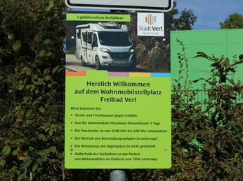 Hinweisschild Das Bild zeigt ein Informationsschild für Wohnmobilstellplätze am Freibad Verl mit Nutzungsregeln.