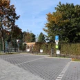 Stellplätze am Freibad Parkplatz mit zwei ausgewiesenen Behindertenparkplätzen, umgeben von Bäumen in herbstlichen Farben.