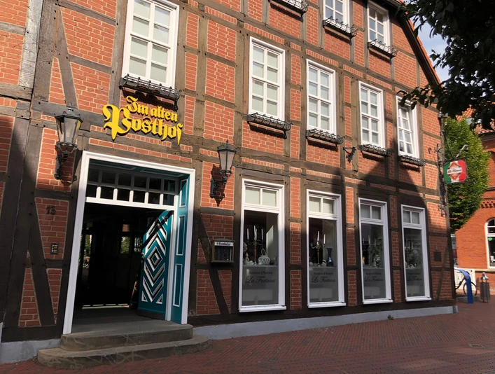 Das Foto zeigt die Fassade eines historischen Fachwerkhauses mit der Aufschrift „Im alten Posthof“.