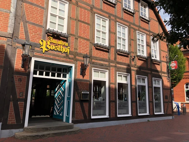 Alter Posthof Das Foto zeigt die Fassade eines historischen Fachwerkhauses mit der Aufschrift „Im alten Posthof“.