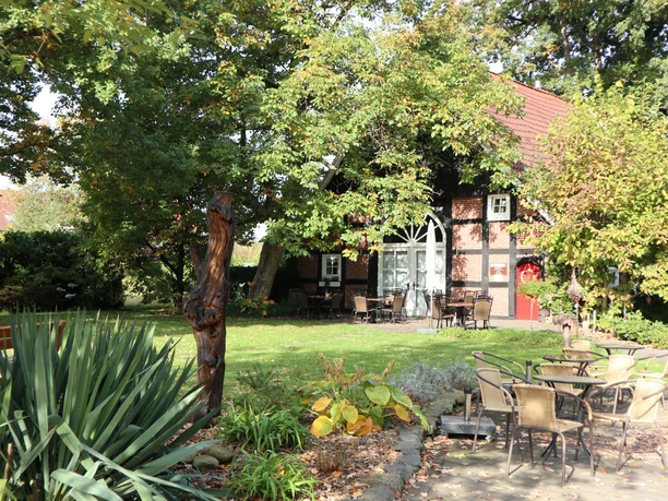 Kötterhaus Kaunitz Ein traditionelles Fachwerkhaus, umgeben von grünen Bäumen, mit einem gemütlichen Außenbereich.