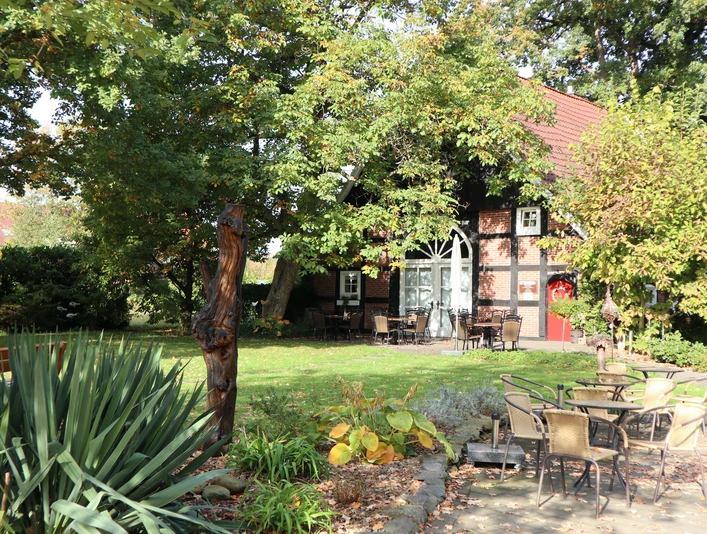 Kötterhaus Kaunitz Ein traditionelles Fachwerkhaus, umgeben von grünen Bäumen, mit einem gemütlichen Außenbereich.