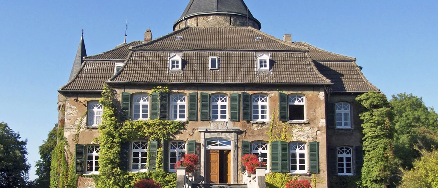 Schloss Linnep in Ratingen Schloss Linnep in Ratingen, umgeben von farbenfroher Begrünung und beeindruckenden Treppen.