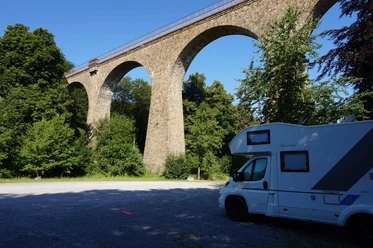 Wohnmobilstellplatz Saubrücke in Velbert Wohnmobilstellplatz nahe der Saubrücke in Velbert, umgeben von grünem Wald und beeindruckendem Viadukt.