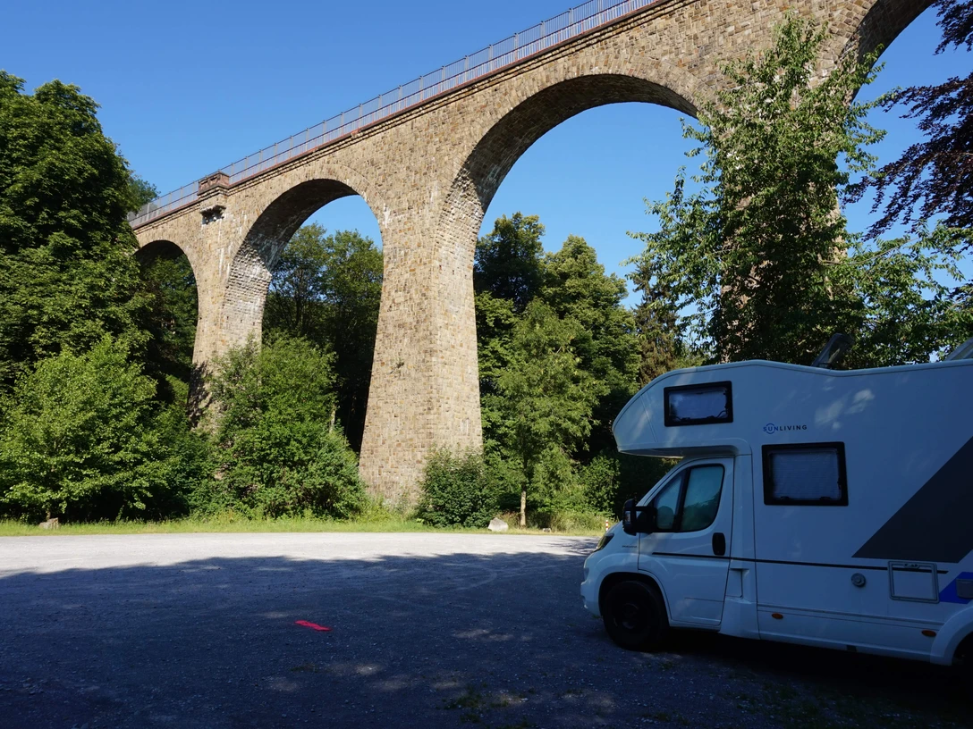 Wohnmobilstellplatz Saubrücke in Velbert Wohnmobilstellplatz nahe der Saubrücke in Velbert, umgeben von grünem Wald und beeindruckendem Viadukt.