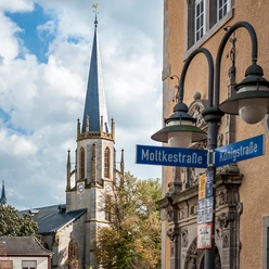 St. Dionysius-Kirche in Rheine mit markantem Turm; Straßenschilder von Moltkestraße und Königstraße.