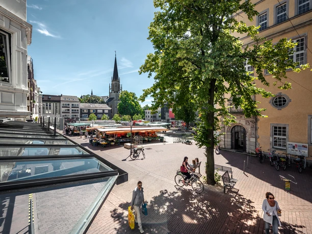 Berliner Platz Belebter Marktplatz in der Innenstadt mit Fußgängern, Radfahrern und St. Martini Kirche im Hintergrund.