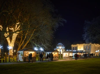 Westfälischer Geschenkemarkt Leuchtende Weihnachtsstände und erleuchtete Bäume zaubern eine festliche Atmosphäre in der Nacht.