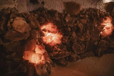 Mauer aus leuchtenden Salzkristallen mit warmem Licht in einer Höhlenatmosphäre.