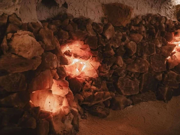 Mauer aus leuchtenden Salzkristallen mit warmem Licht in einer Höhlenatmosphäre.
