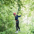 Kletterpark Interakteam_Teutoburger Wald_Leon Neufeld_CCBYSA.jpg Ein junger Kletterer balanciert auf einem Seilparcours in einem grün bewachsenen Kletterpark.