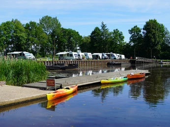Kanuverleih am Hammehafen.JPG Mehrere bunte Kanus liegen am Holzsteg des Hammehafen, dahinter Wohnmobile und Bäume.Several colorful canoes are moored on the wooden jetty of the Hammehafen, with motorhomes and trees behind them.Flere farverige kanoer ligger fortøjet på træbryggen i Hammehafen, med autocampere og træer bagved.Verschillende kleurrijke kano's liggen aangemeerd aan de houten steiger in de haven van Hammehafen, met campers en bomen erachter.