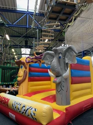 Hüpfburg im Okidoki Kinderland in Langenfeld Hüpfburg mit bunten Elementen und Tiermotiven, darunter ein Elefant und eine Giraffe, im Indoor-Spielbereich.