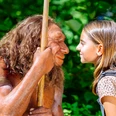 Gesichtervergleich mit MR N und Mädchen Ein Mädchen steht einem Neandertaler-Modell gegenüber, beide blicken sich intensiv in die Augen.