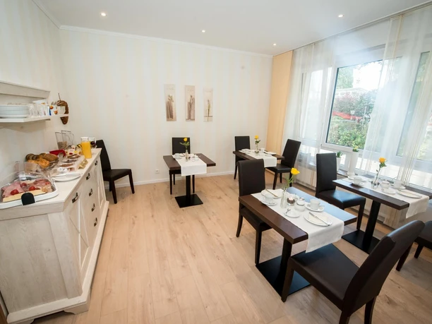 Frühstücksbereich mit vier Tischen.