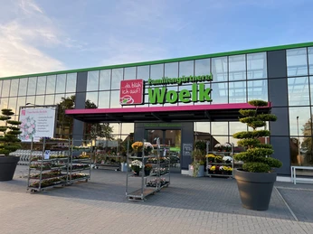 Café Karl Nienburg Eingang der Gärtnerei Woelk mit farbenfroher Pflanzenvielfalt und modernen Gestaltungselementen.