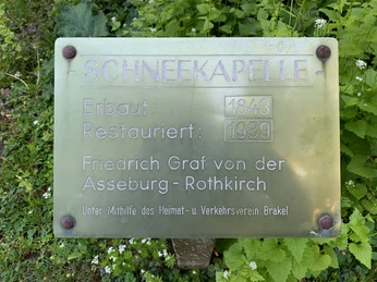 Tafel mit Infos: Schneekapelle Brakel, Baujahr 1843, Restaurierung 1989, unterstützt vom Heimatverein.