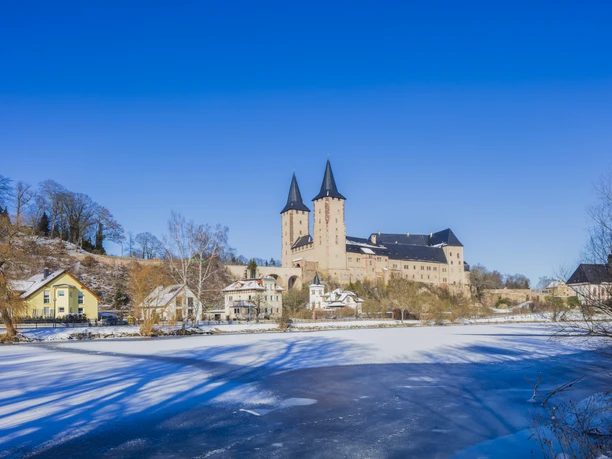 General view of Rochlitz Castle in snow with the frozen Mulde in the foreground, Mulde Cycle Path, Luther Trail Saxony