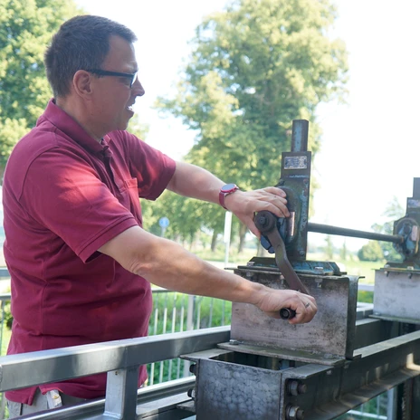 Von Hand stoppt Andres Jansen den Wasserzufluss, damit das Mühlenrad stehen bleibt.