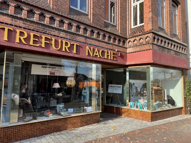 A historic bookstore in a reddish-brown brick building with large display windows.